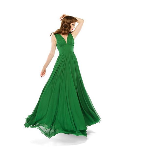 A woman in a flowing green gown poses gracefully on a white background.