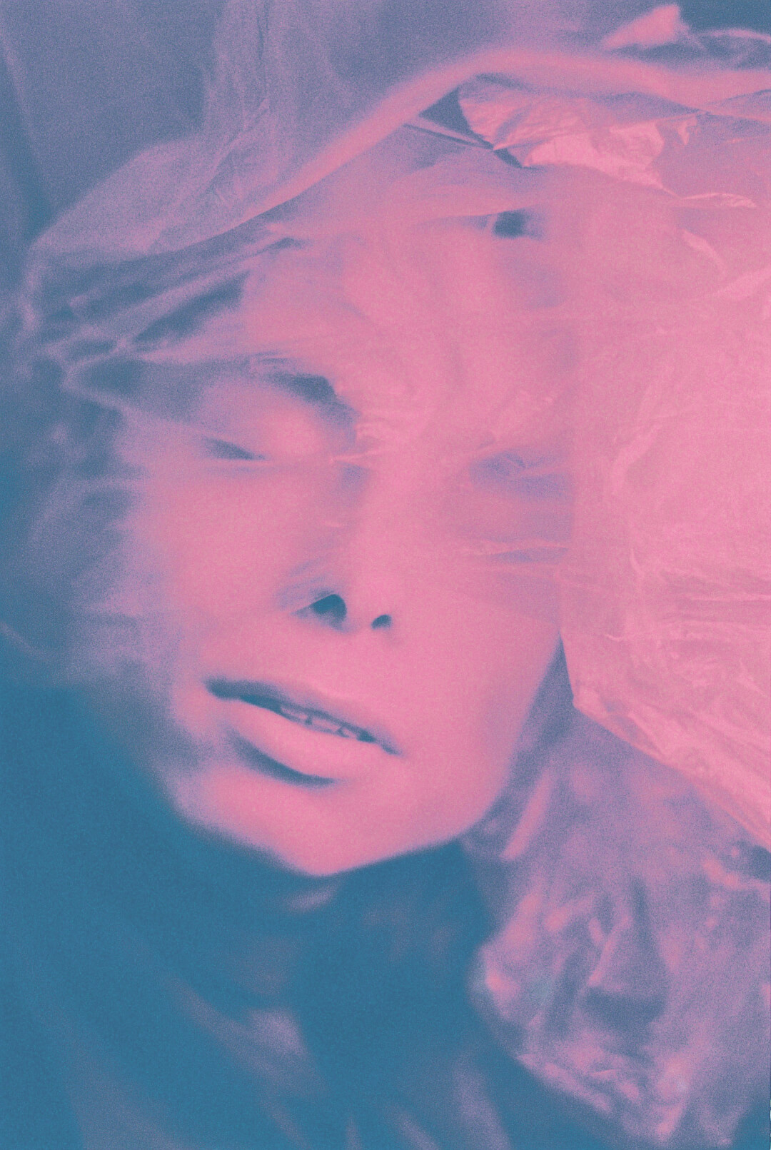 A dreamy portrait of a woman's face distorted by a pink and blue filter, evoking mystery and emotion.