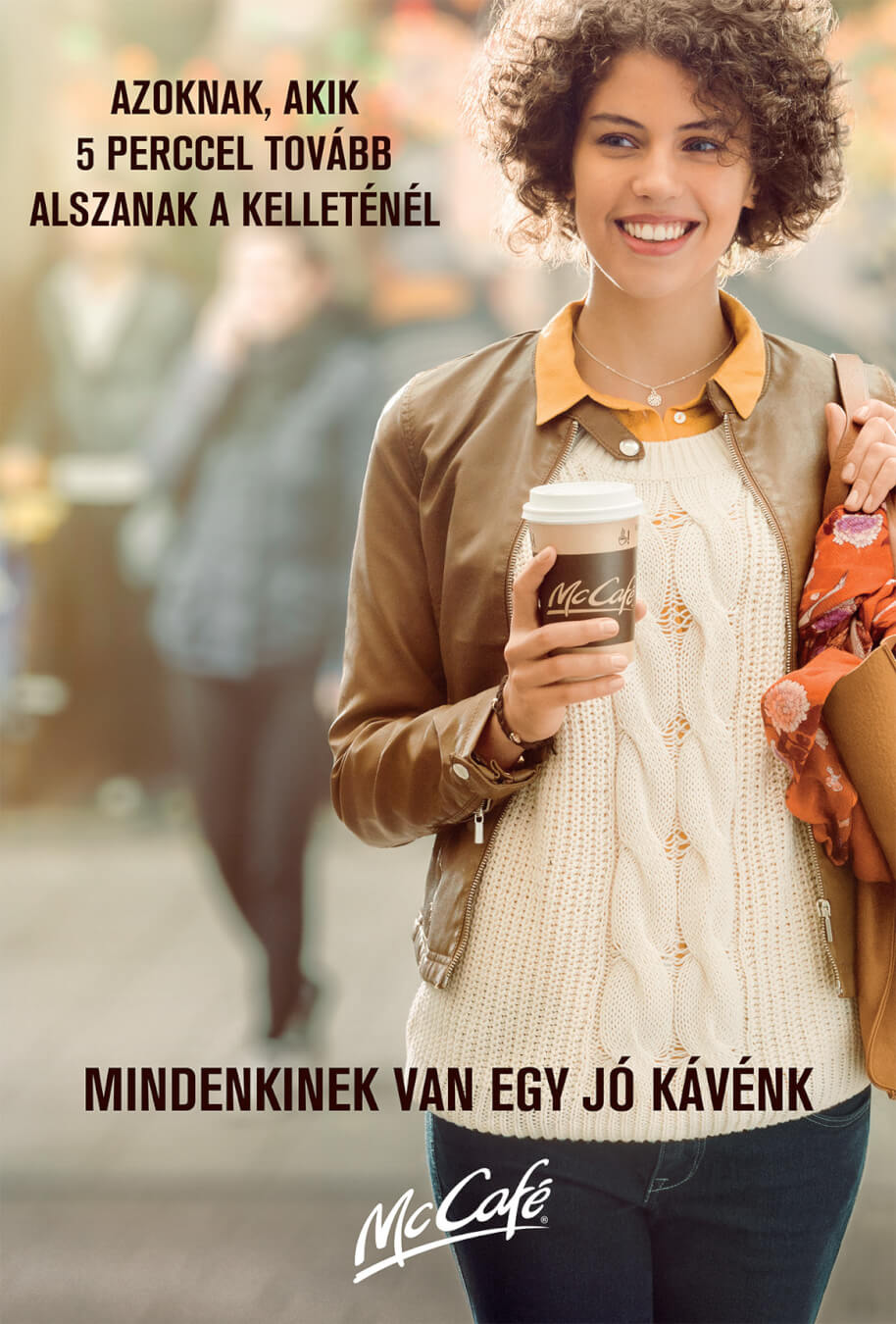 A smiling woman enjoys McCafe coffee while walking in the city in this advertisement.