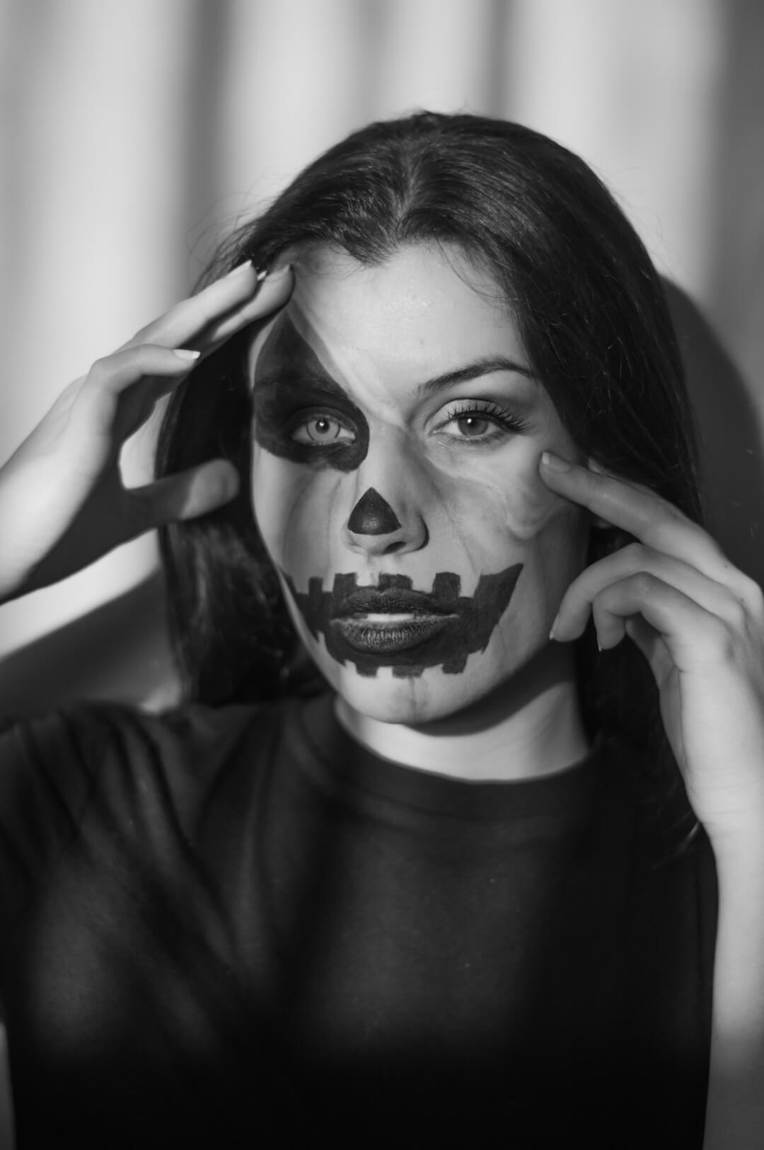 Monochrome portrait of a woman in Halloween makeup striking a pose. Perfect for seasonal designs.