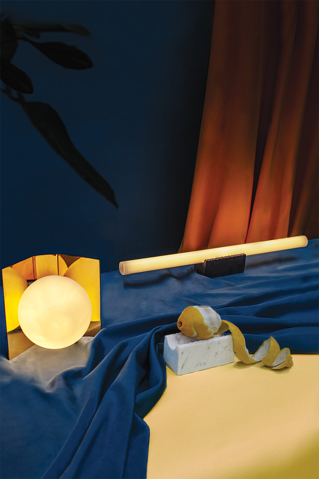 A still life composition with lemon, lamps and draped fabric, evoking a dreamy and contemplative mood.