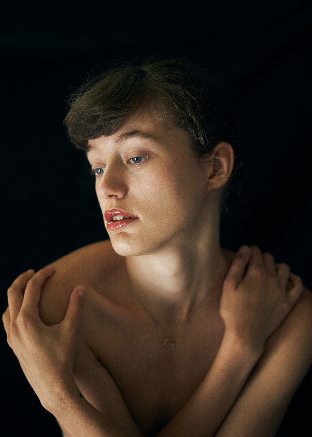 Intimate studio portrait of a young woman with soft lighting and a dreamy, delicate mood, perfect for editorial use.