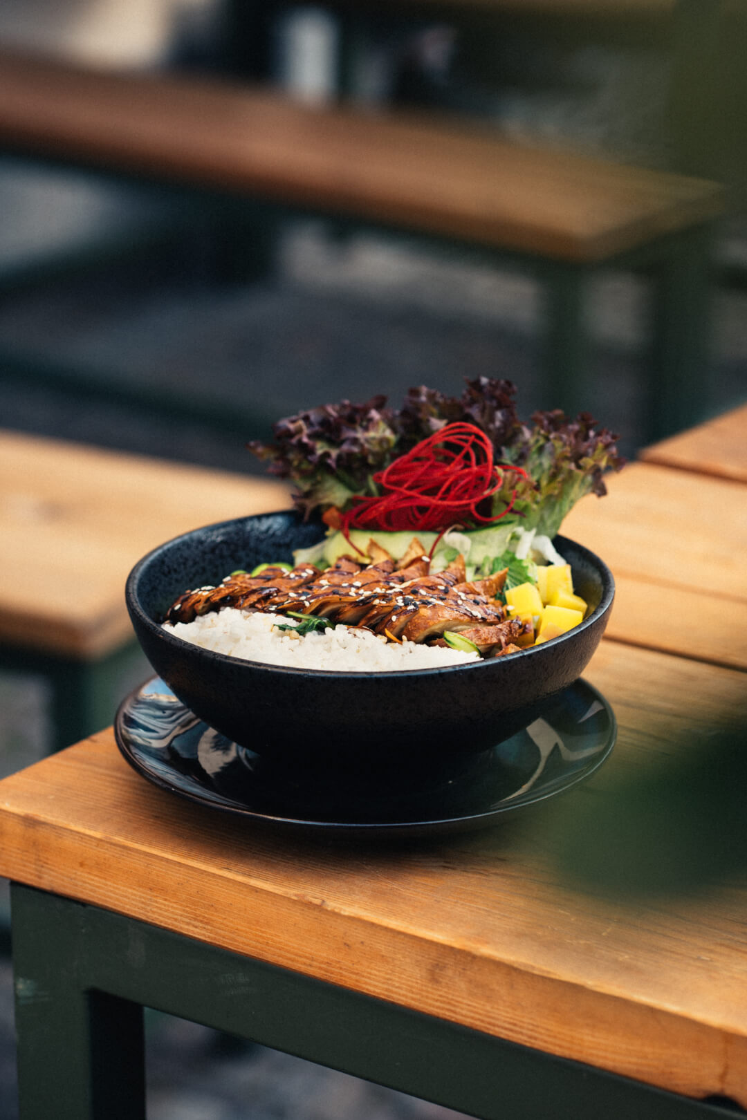 A delicious chicken and rice bowl with salad, perfect for a restaurant promotion or healthy eating campaign.