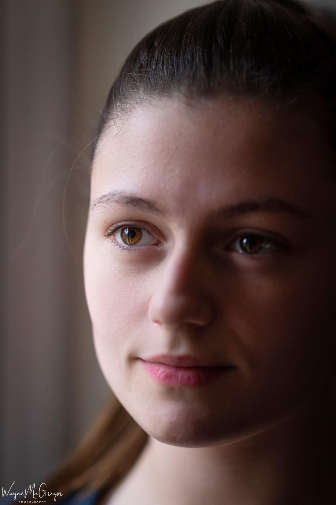 Close-up portrait of a serene young woman with soft, natural lighting and a shallow depth of field.