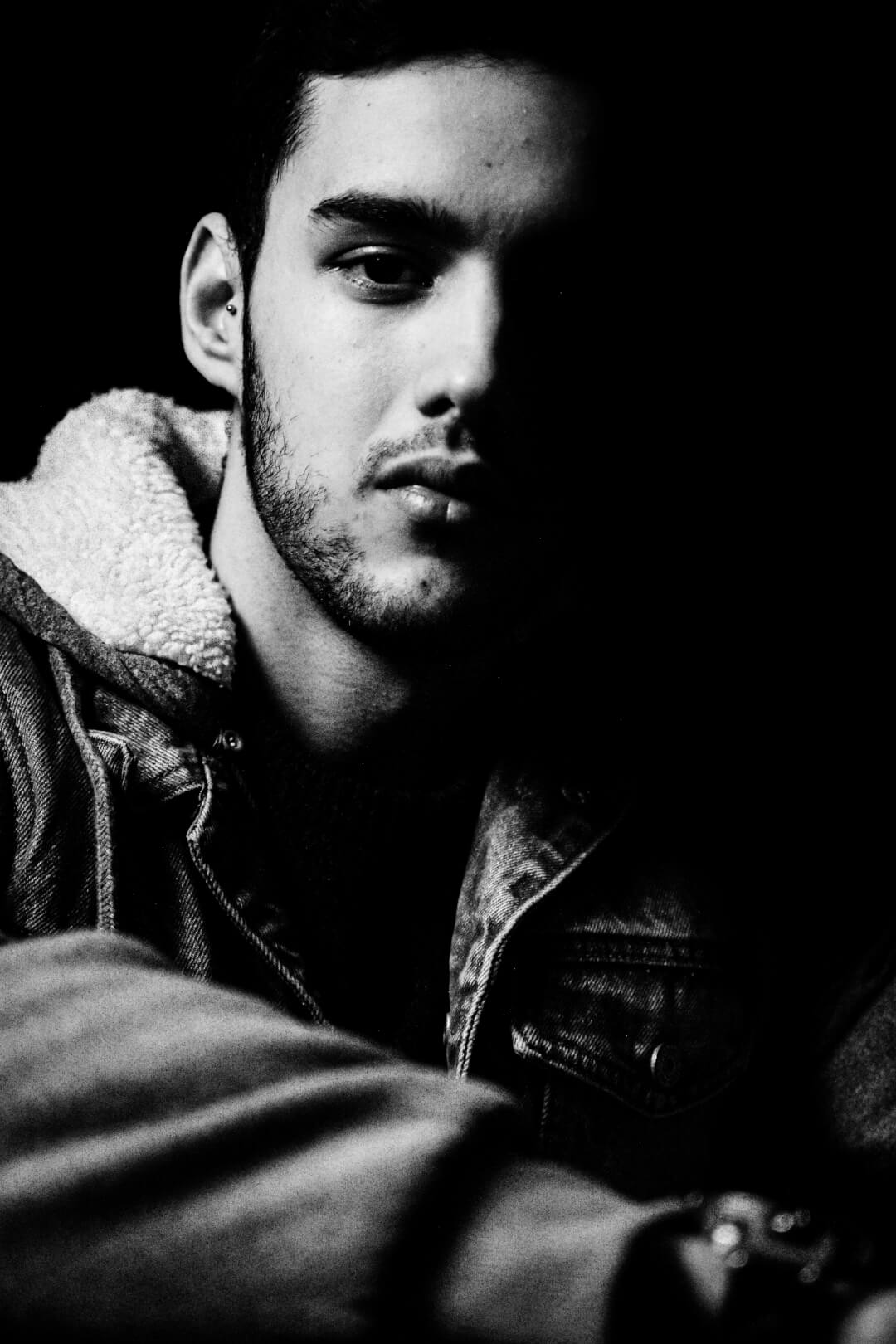 A striking black and white portrait of a man with dramatic lighting and high contrast.