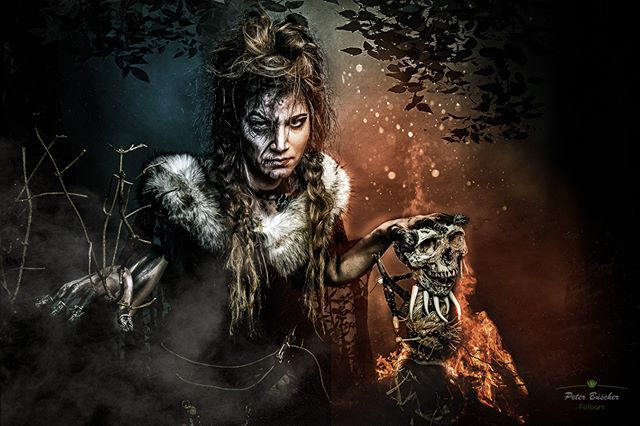 A dramatic image of a witch holding a skull in a dark forest setting, perfect for fantasy or halloween themes.