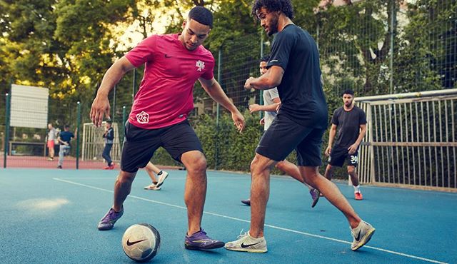 Athletes play soccer in an outdoor urban setting, showcasing energetic fitness and sports branding in action.