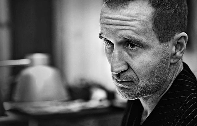 A black and white portrait of a serious man looking off to the side in a moment of contemplation.
