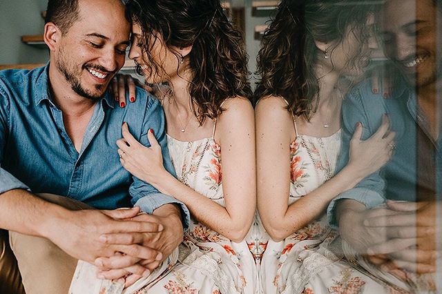 A couple shares an intimate, tender moment, embracing in a soft, natural light setting.