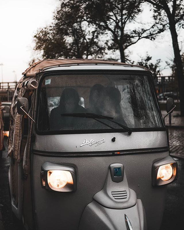 A classic Piaggio Ape Calessino auto rickshaw stands ready for urban adventures in muted tones.
