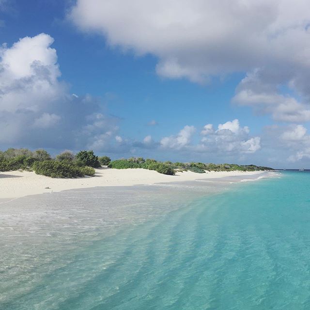 A beautiful tropical beach with turquoise water, white sand, and blue sky, perfect for vacation and relaxation.
