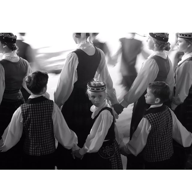 A group of people in traditional clothing holding hands in a circle.