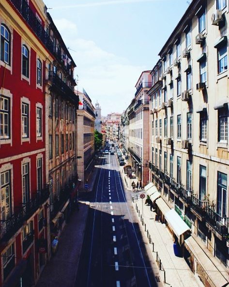 A vibrant city street lined with colorful buildings under a bright sky, perfect for travel and architecture enthusiasts.