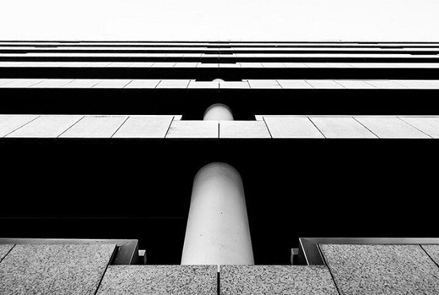 Abstract low angle architectural shot of a modern building with strong lines and white columns.
