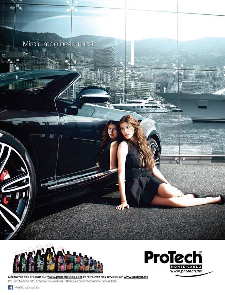 Elegant woman poses next to a luxury car reflecting the Monaco cityscape. Brand Protech Monte Carlo in view.
