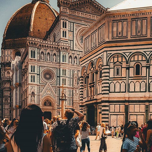 Florence Cathedral and Baptistery attract tourists. Historic buildings showcase renaissance architecture in a bustling Italian city.