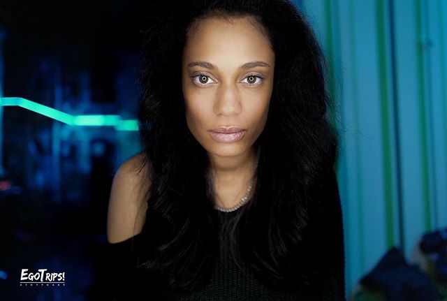 A striking portrait of a woman with an intense gaze, captured in soft, cool-toned lighting for a professional look.