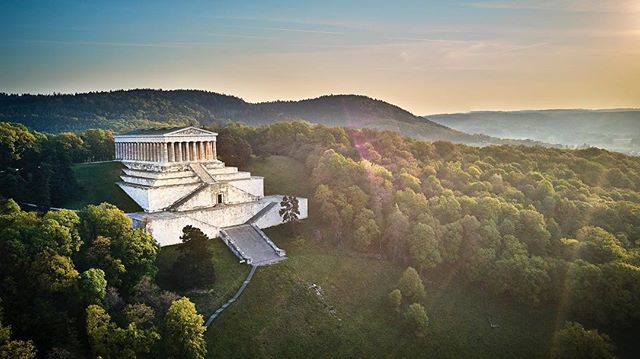 Walhalla monument sits atop a forested hill under a clear sky, a famous historical landmark.