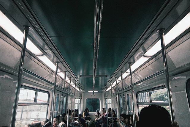 People ride in a subway car, traveling on public transportation in the city. 