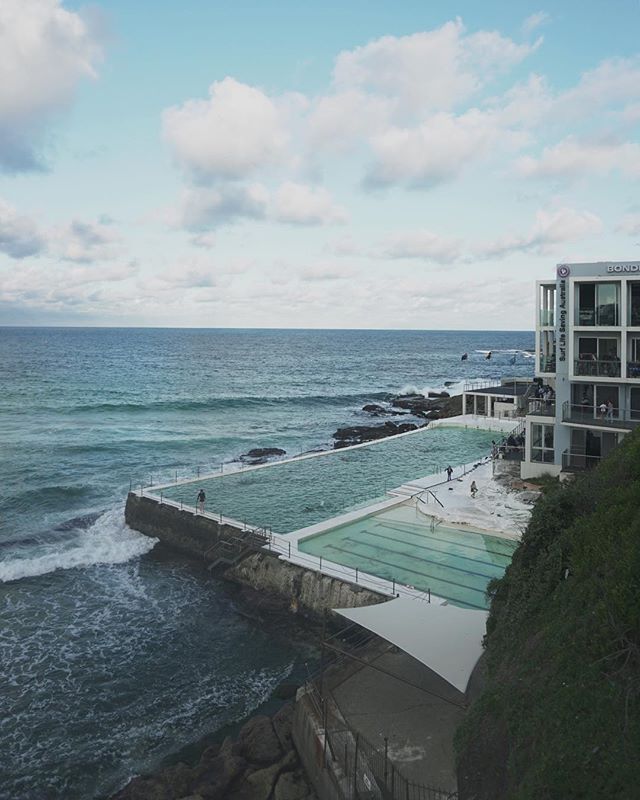 Bondi Icebergs ocean pool beside the ocean under a cloudy sky in Australia for travel and tourism campaigns.