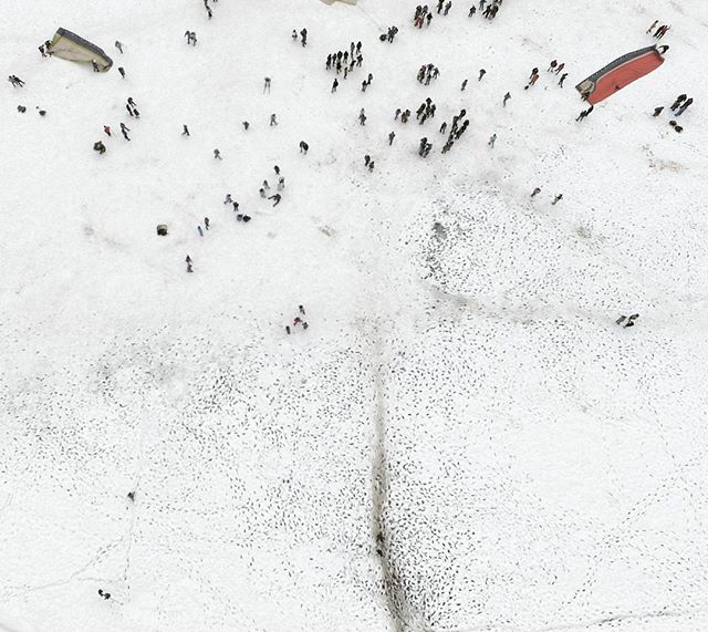 Aerial view shows people around the wreckage of an aircraft in a snowy field after a crash.