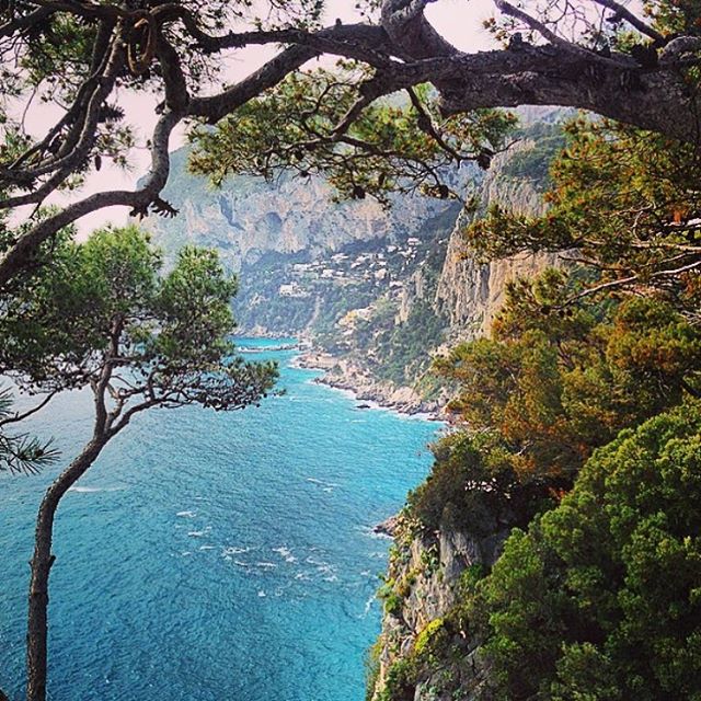 A scenic view captures a breathtaking coastal landscape with vibrant blue sea and lush green cliffs, perfect for travel inspiration.