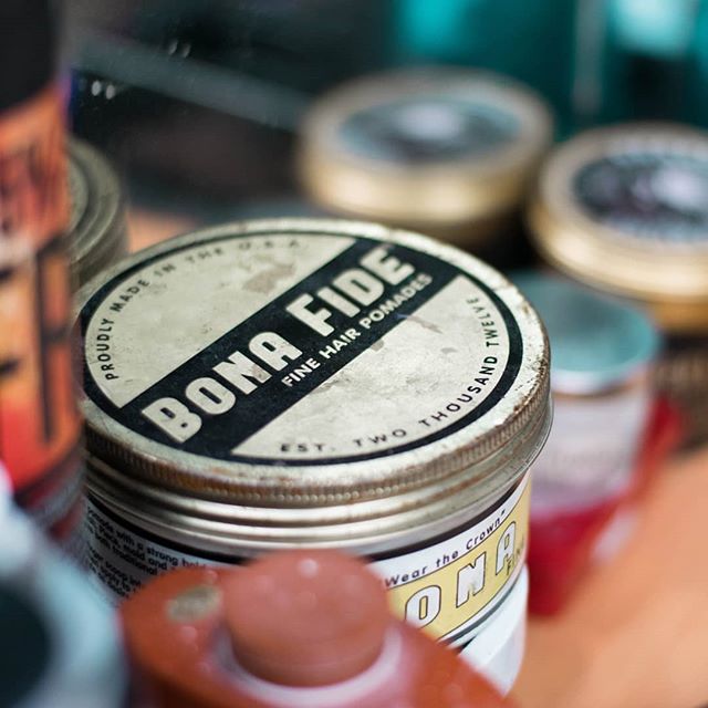 A close-up showcases Bona Fide hair pomade in vintage packaging, ideal for men's grooming and classic style promotions.