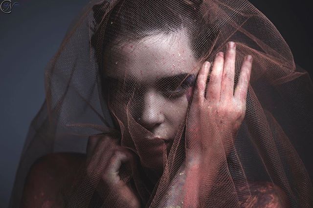 An artistic and moody portrait of a woman with a veil, evoking mystery and emotion.