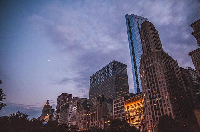 Chicago skyline at dusk featuring modern skyscrapers and historic buildings under a cloudy sky.