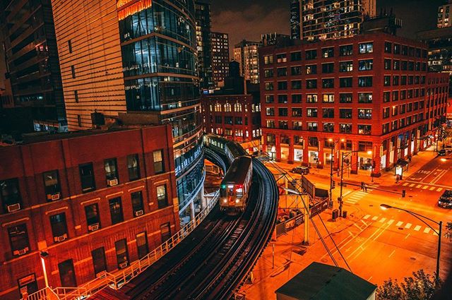 An elevated train winds through the Chicago Loop, illuminated against the night sky, showcasing the city's vibrant urban landscape.
