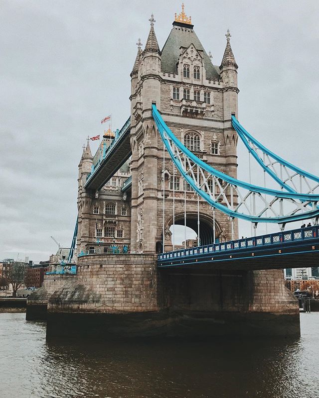Tower Bridge over the River Thames in London, UK on an overcast day.