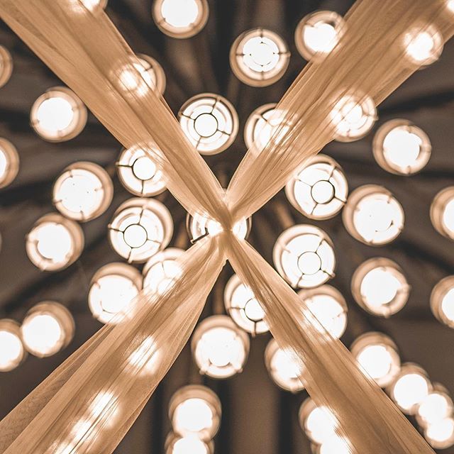 Illuminated lights and soft fabric create an elegant abstract pattern on the ceiling.