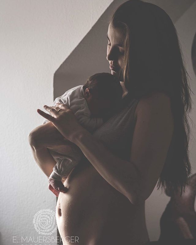 A mother tenderly holds her newborn baby in a soft, intimate embrace.
