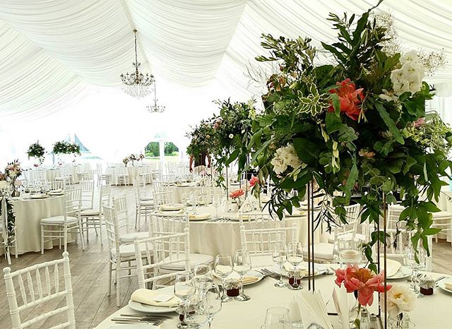 An elegant wedding reception setup with floral centerpieces and formal table settings.