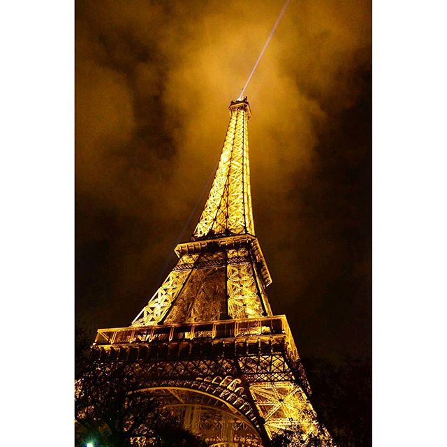 The Eiffel Tower glows in Paris at night, creating a dreamy and tranquil cityscape. 