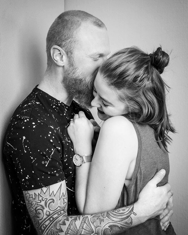 A man and woman embrace in a tender, loving moment, captured in black and white.