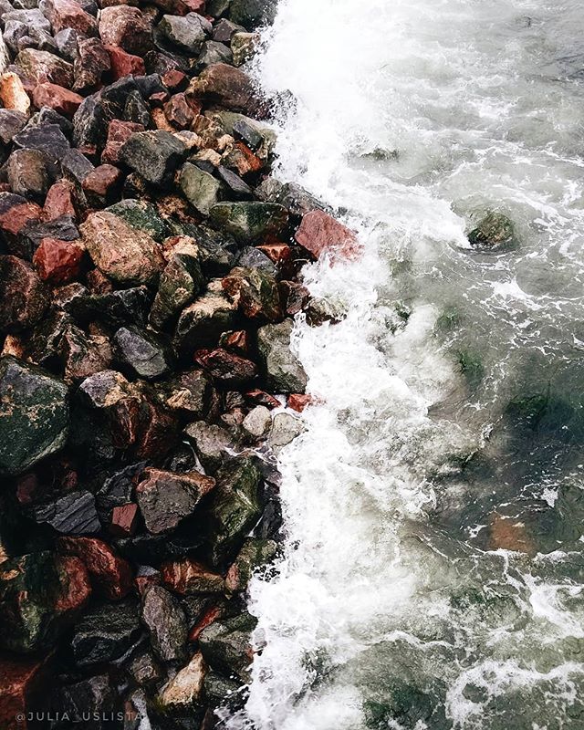 A scenic view of ocean waves crashing on a rocky shore creating a peaceful and natural ambiance.