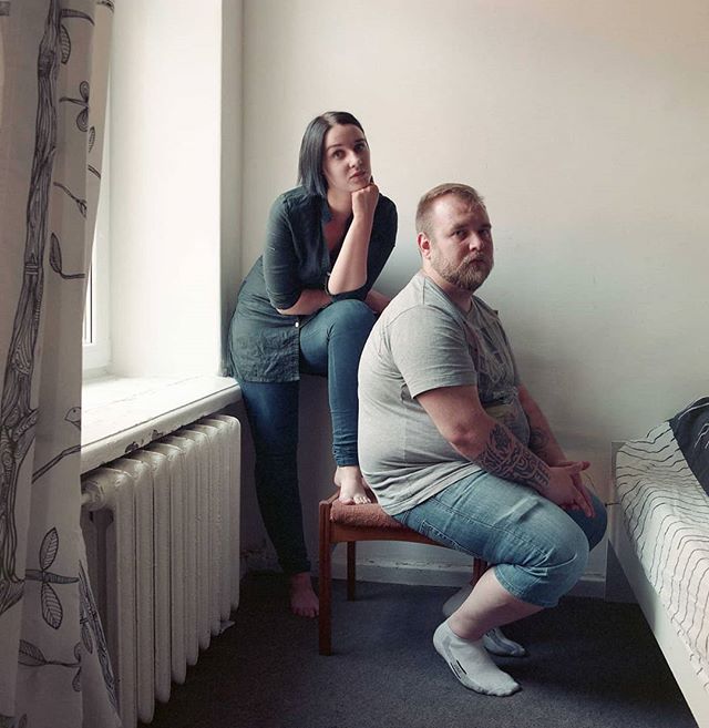 A man and woman pose indoors for a relaxed, medium shot, portraying a calm domestic scene.