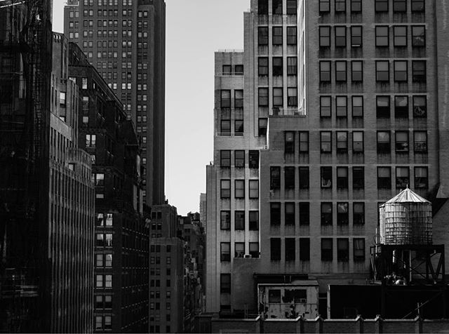 Black and white cityscape featuring skyscrapers and a water tower, capturing the essence of urban architecture.