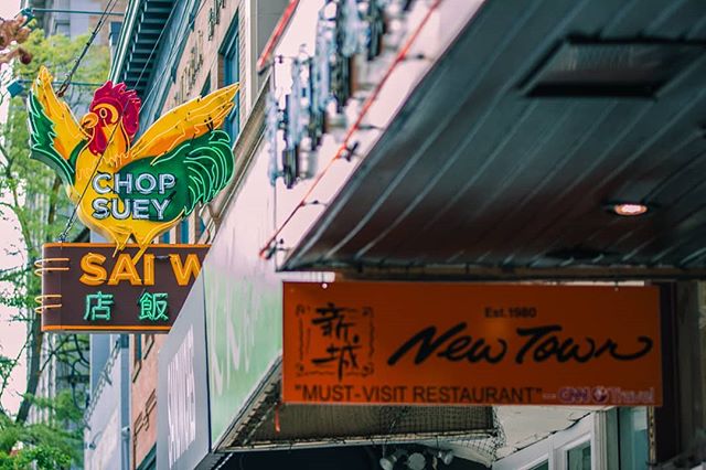 A vibrant shot showcasing two restaurant signs, 'Chop Suey Sai W' and 'New Town Restaurant'.