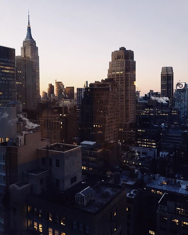 A cityscape of New York City features the Empire State Building at dusk, showcasing a blend of architectural grandeur and urban tranquility.