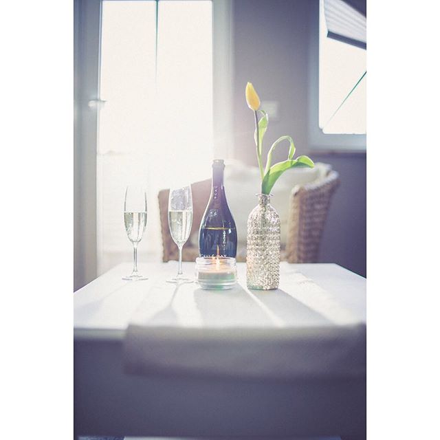 An elegant still life composition with champagne, a tulip, and candle creates a soft and intimate mood.