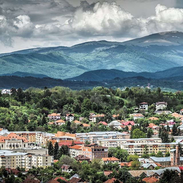 A cityscape nestled among rolling mountains, showcasing a blend of urban development and natural beauty.