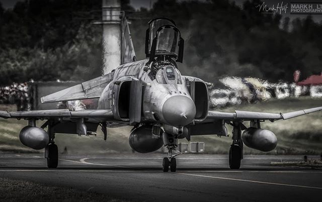 An F-4 Phantom fighter jet sits on the runway, a powerful symbol of military aviation and aerospace technology.