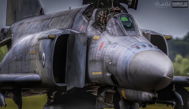 A close-up of a F-4 Phantom fighter jet on an airfield, showcasing its powerful and intense military design.