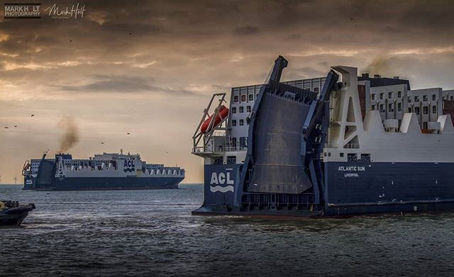 A cargo ship, Atlantic Sun, is on the water with a grey sky in the background.