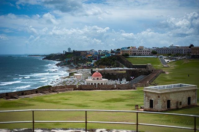 A scenic view of a cemetery and cityscape along the Puerto Rico coastline, perfect for travel and heritage promotions.