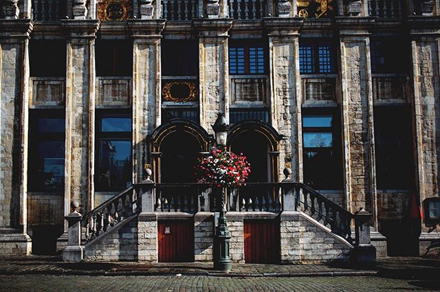 A detailed shot of a historic building facade with ornate stone work and a vintage street lamp.