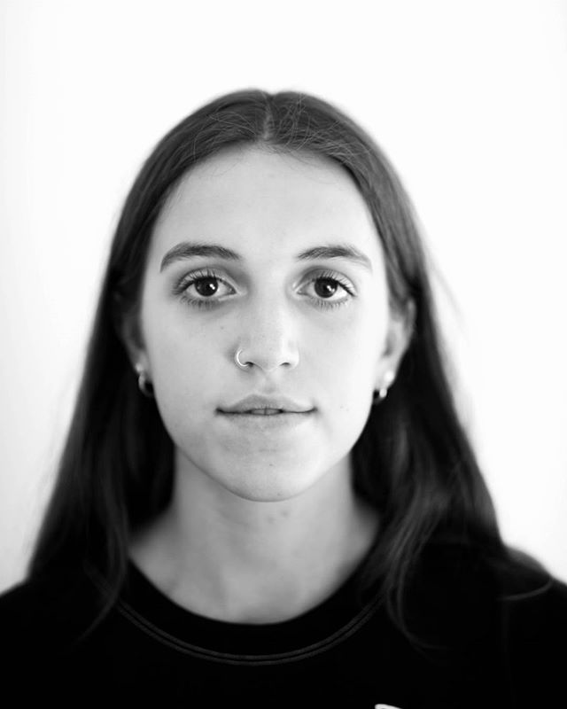 A portrait of a young woman with long dark hair in black and white.