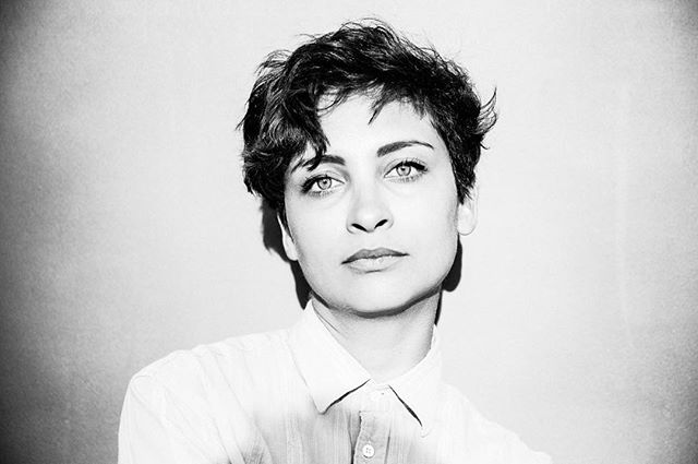 A black and white portrait of a woman with short hair, showcasing confidence and intensity.